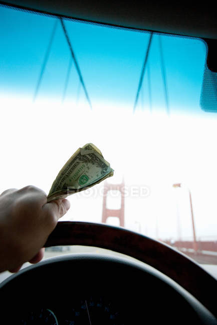Pessoa portagem segurando dinheiro para Golden Gate Bridge — Fotografia de Stock
