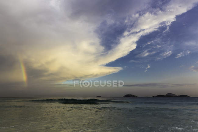 Arco iris en el cielo sobre el mar - foto de stock