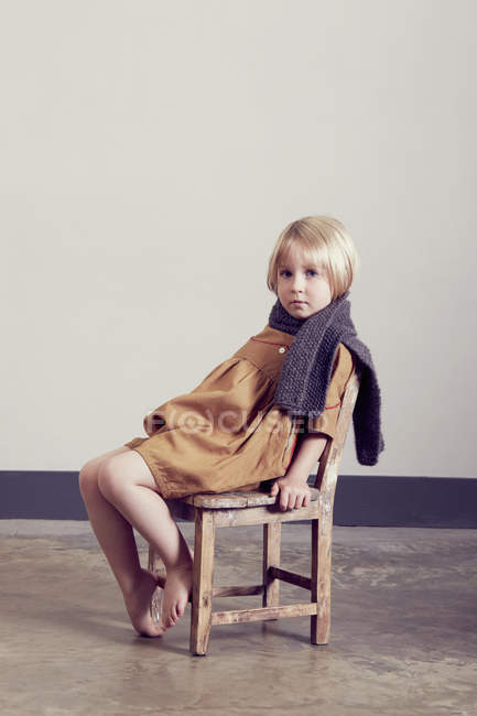 Ritratto di ragazza macchiata seduta su una vecchia sedia di legno — Foto stock