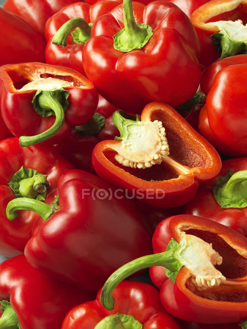Whole and sliced red bell peppers — Stock Photo