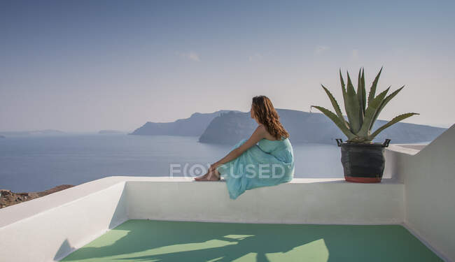 Женщина на террасе с видом на море, Санторини, Киклады, Греция — стоковое фото