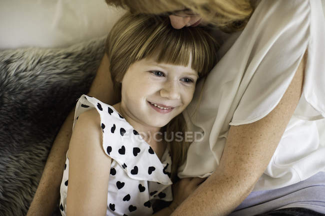 Mãe e filha abraçando na cama — Fotografia de Stock