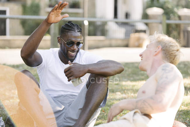 Two young men high fiving each other in park — Stock Photo