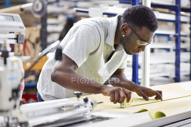 Worker assembling roller blind on production line in factory — Stock Photo