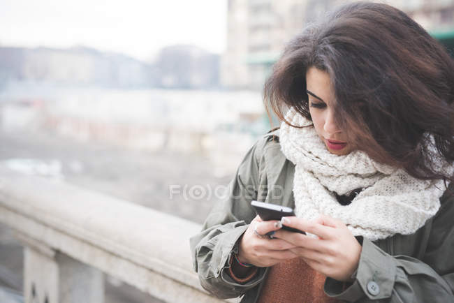 Молода жінка текстові повідомлення на смартфоні — стокове фото