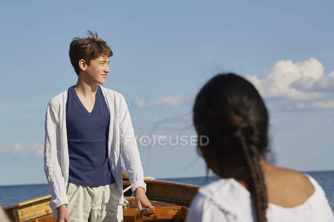 Young people on boat looking away in blue ocean — Stock Photo
