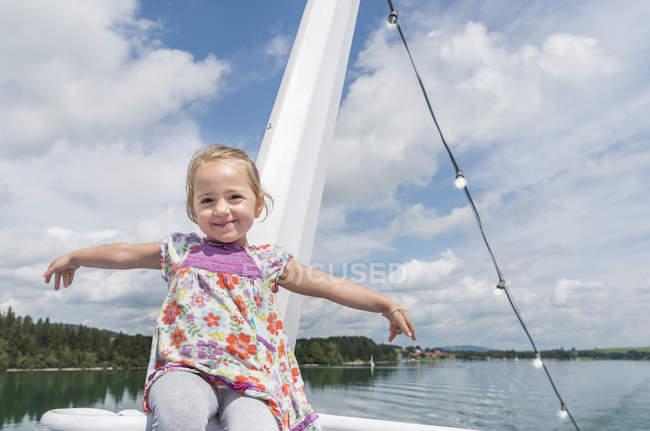 Retrato de menina no barco olhando para a câmera sorrindo, Fuessen, Baviera, Alemanha — Fotografia de Stock