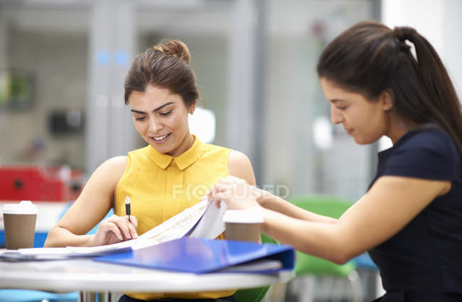 Business women with paperwork in meeting together — Stock Photo