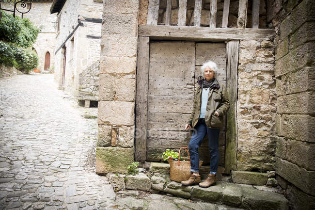 Mulher encostada à porta de madeira, Bruniquel, França — Fotografia de Stock