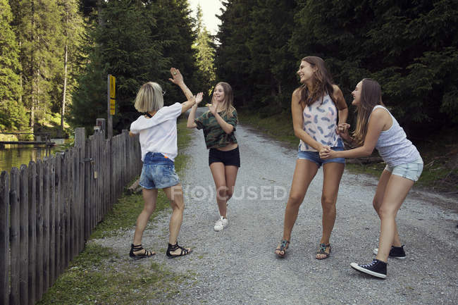 Menina e adultos amigos do sexo feminino alta cinco na trilha da floresta — Fotografia de Stock