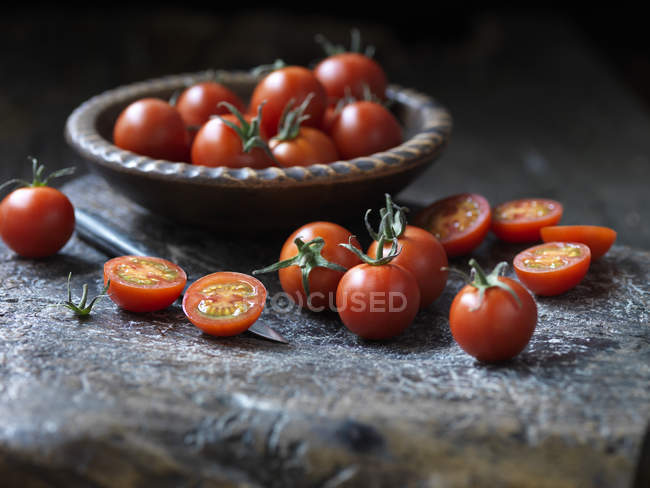 Pomodori freschi biologici in ciotola e in tavola — Foto stock