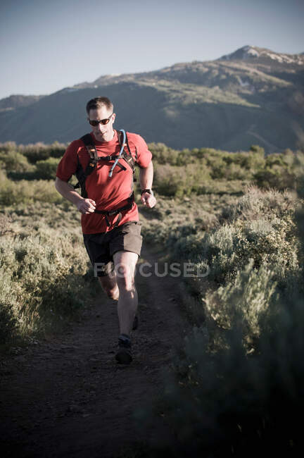 Hombre corriendo en el paisaje rural - foto de stock