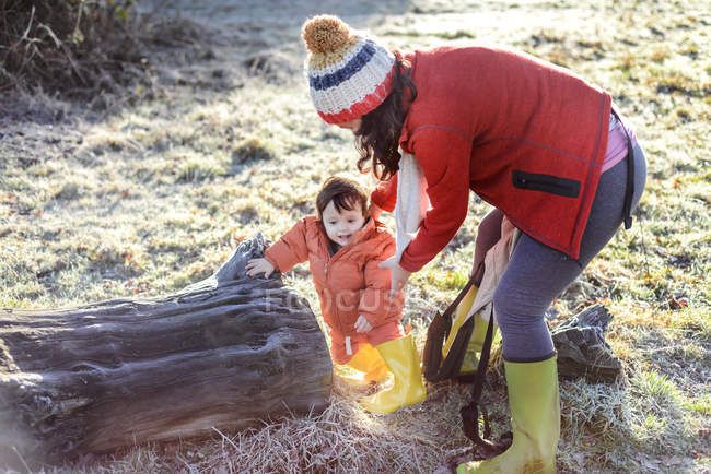 Mother steadying baby boy, outdoors, in winter — Stock Photo