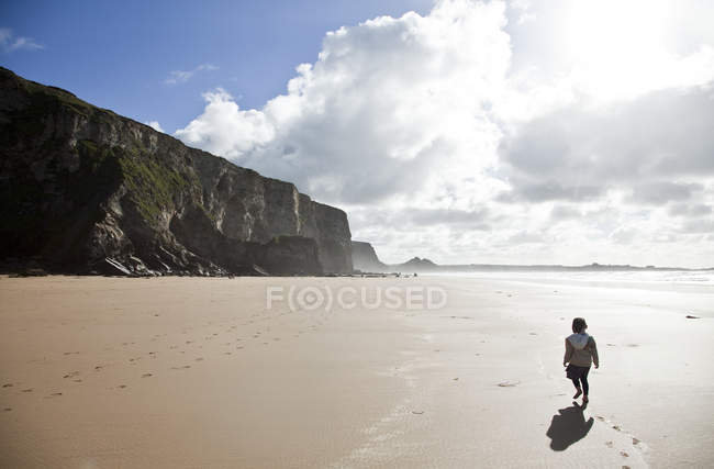Fille marchant sur la plage, Watergate Bay, Cornwall — Photo de stock