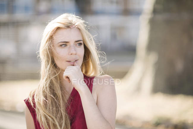 Ritratto di bella giovane donna con lunghi capelli biondi nel parco — Foto stock