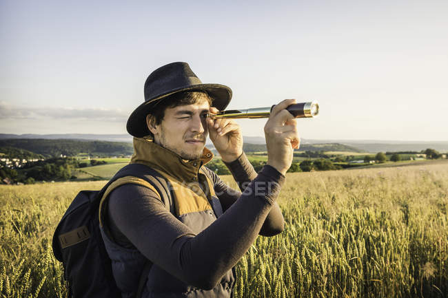 Afleiding kans Fonkeling Mid adult man, standing in field, looking through telescope, Neulingen,  Baden-W?rttemberg, Germany — freedom, 30 to 34 years - Stock Photo |  #168142976