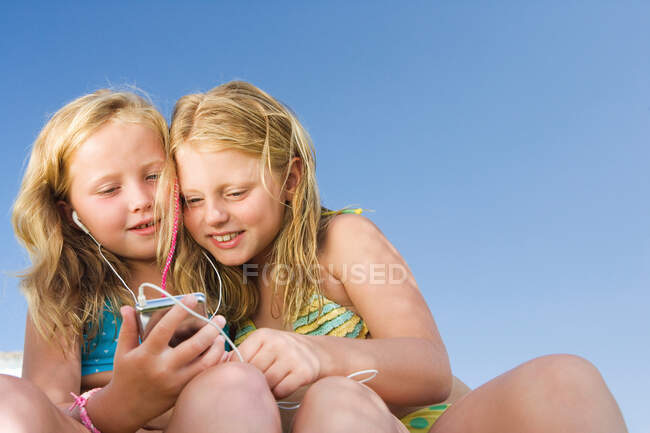 Two young girls sharing an ipod — Stock Photo