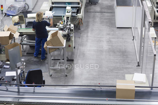 Mature woman working in paper packaging factory — Stock Photo