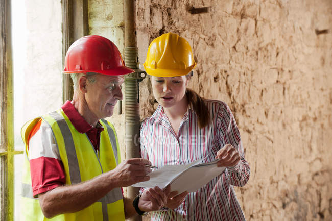 Construction workers examining papers — Stock Photo