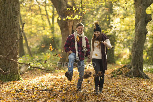 Young couple walking through autumn forest — Stock Photo