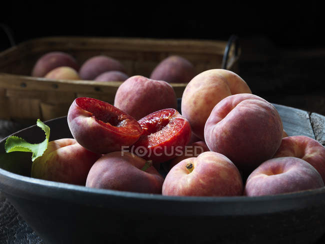 Fresh organic red apricots with leaf in bowl — Stock Photo