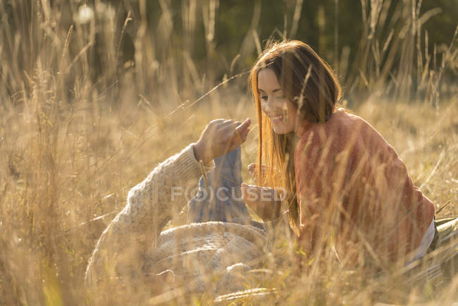 Giovane coppia sdraiata in erba alta sul campo — Foto stock