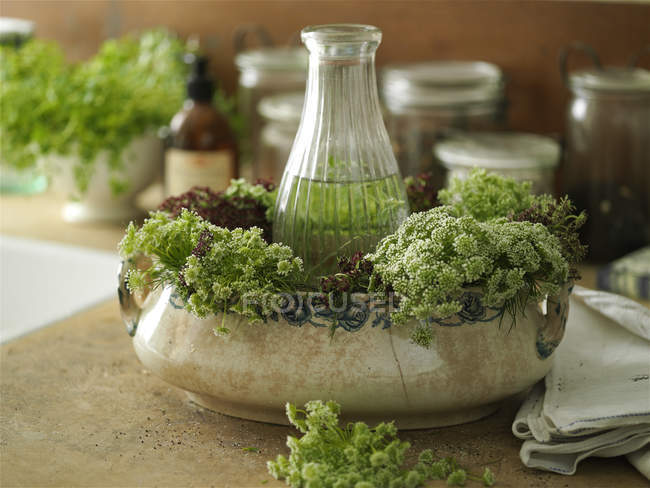 Flower arranging with wildflowers and vintage bowl on kitchen counter — Stock Photo