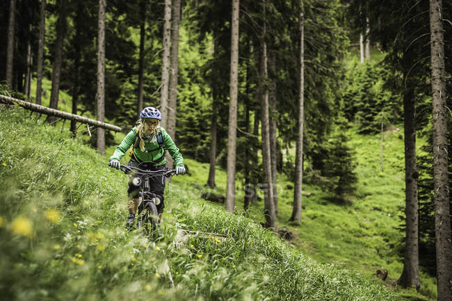 Woman mountain bike on hillside, Meran, South Tyrol, Itália — Fotografia de Stock