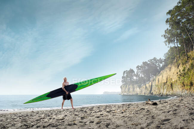 Surfer trägt Surfbrett an Strand, Santa Cruz, Kalifornien, USA — Stockfoto