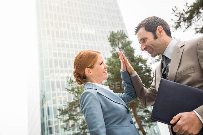 Business people high fiving outdoors — Stock Photo