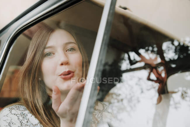 Пара пассажиров, сидящих в машине, женщина, дующая в поцелуй — стоковое фото