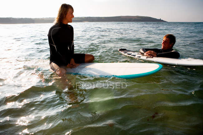 Couple floating on surfboards — Stock Photo