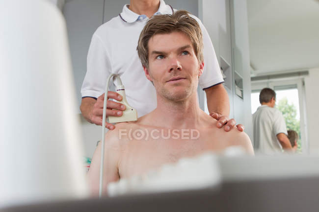 Médico con ecografía en el paciente - foto de stock