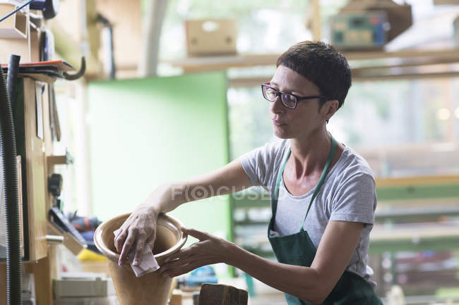 Woman in workshop polishing alphorn — Stock Photo