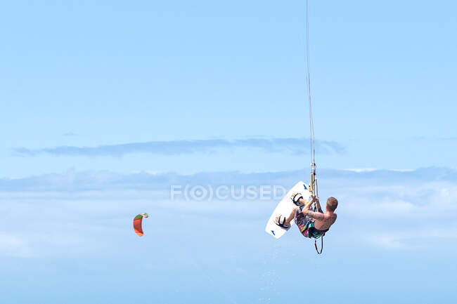 Man in mid air kite surfing — Stock Photo