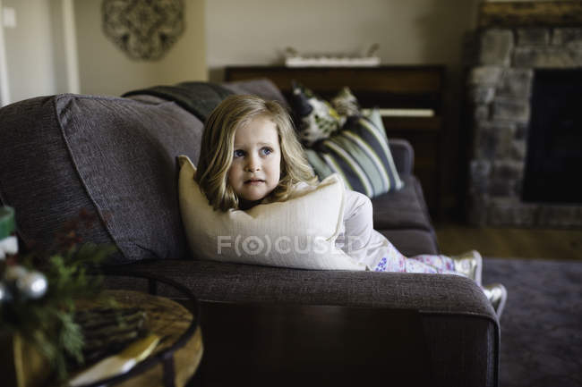 Paura ragazza guardando lateralmente dal divano — Foto stock