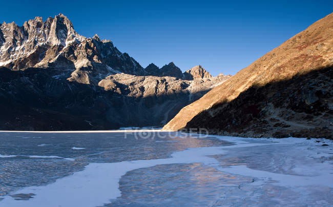 Mountains overlooking frozen valley — Stock Photo