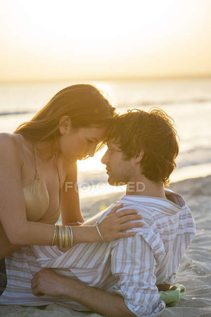 Romântico jovem casal reclinado na praia ao pôr do sol, Maiorca, Espanha — Fotografia de Stock