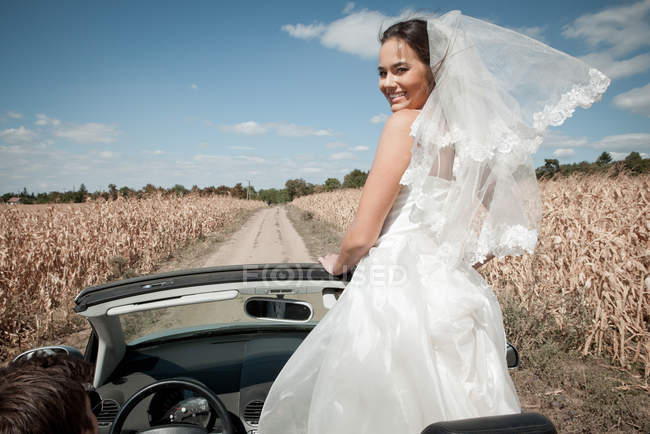 Coppia di sposi alla guida in cabriolet — Foto stock