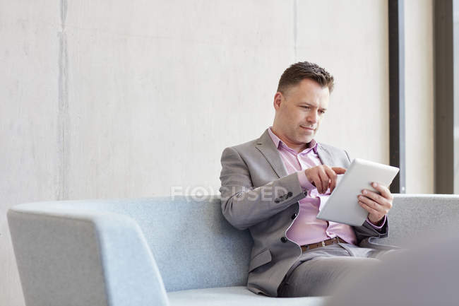 Uomo d'affari che utilizza touchscreen tablet digitale in ufficio — Foto stock