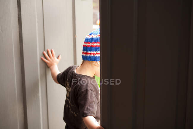 Niño caminando a través de la puerta - foto de stock
