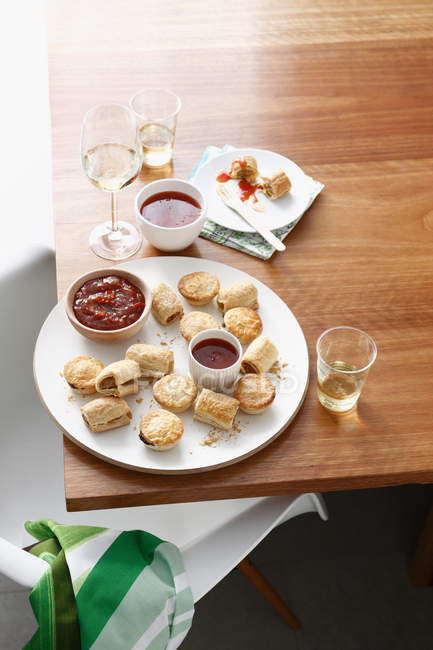Plate of baked tarts with dipping sauce — Stock Photo