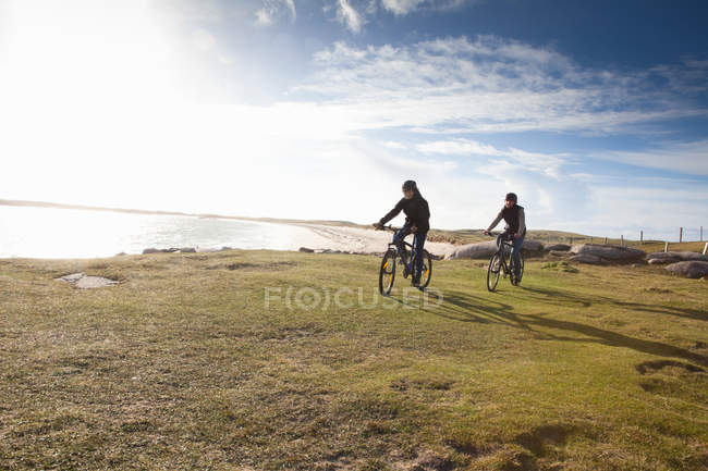 Ciclismo en pareja por costa, Connemara, Irlanda - foto de stock