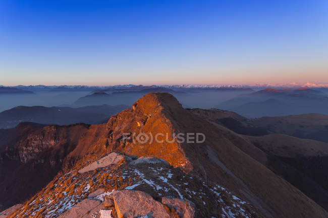 Сонячний гірський пейзаж з віддаленими засніженими горами — стокове фото