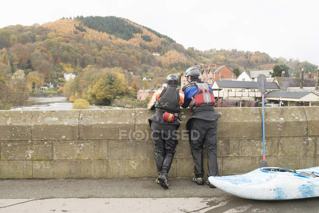 Rear view of two kayakers looking out from bridge on River Dee, Llangollen, North Wales — Stock Photo
