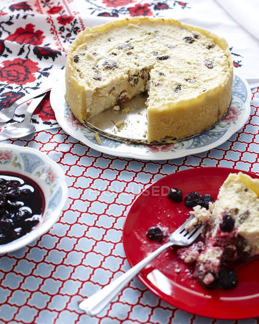 Natura morta di torta di formaggio su piatto con una ciotola di mirtilli — Foto stock