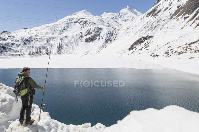 Hombre adulto medio, pesca, Lago Morasco, Morasco, Val Formazza, Piemonte, Italia - foto de stock