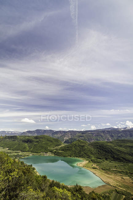 Vista aérea en Kalterer Ver lago y verdes colinas bajo el cielo nublado - foto de stock