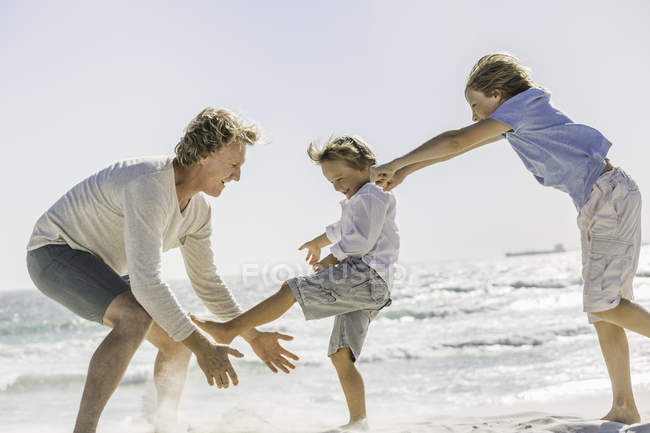 Père et fils jouant sur la plage — Photo de stock