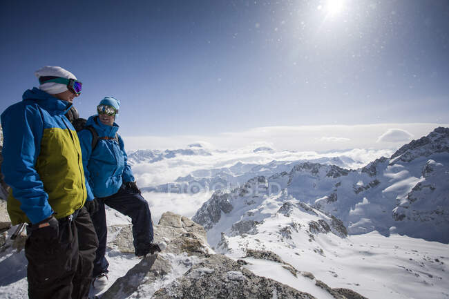 Deux snowboarders mâles surplombant un paysage enneigé, Trient, Alpes suisses, Suisse — Photo de stock